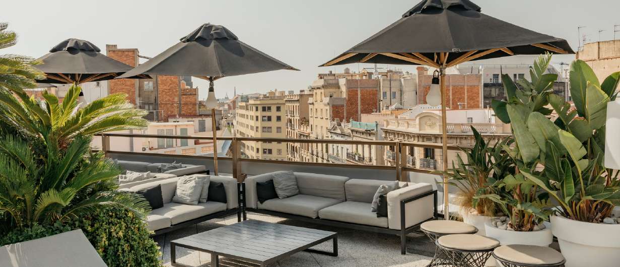 Claris rooftop terrace with outdoor seating and Barcelona views