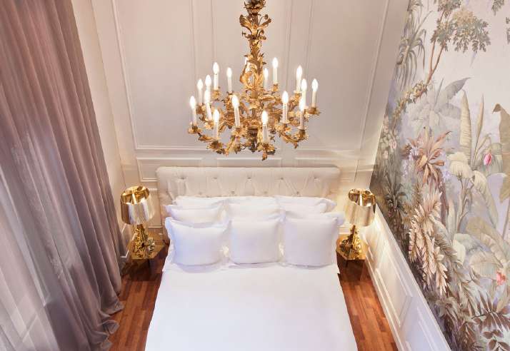 Claris hotel bedroom with chandelier and refined decorative details